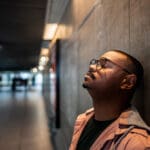 Man-leaning-against-wall-sad-1000×667 man leaning against a wall looking upset and defeated.